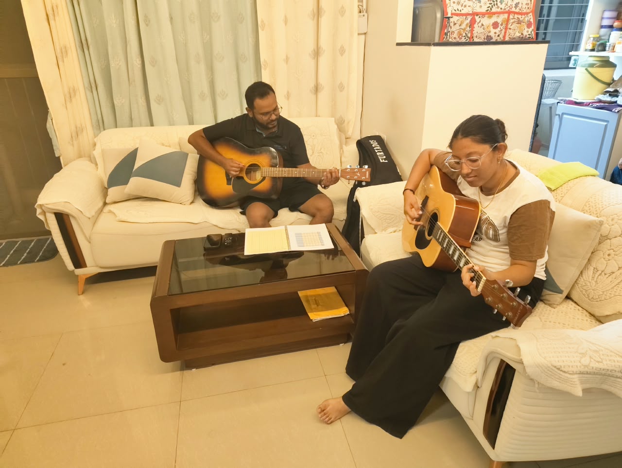 A PKUNPLUGGED instructor and student playing acoustic guitars together during a one-on-one lesson